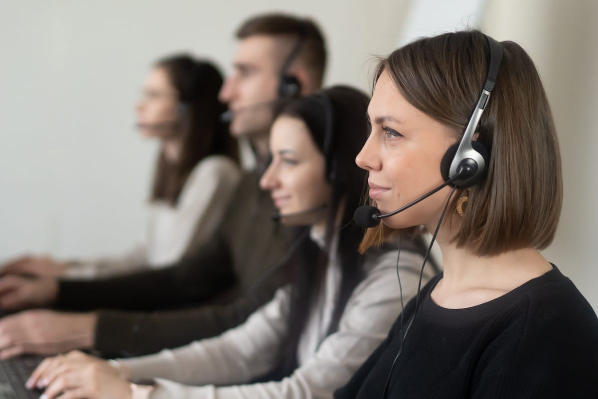 A row of professional call center agents wearing headsets, focused on serving clients.